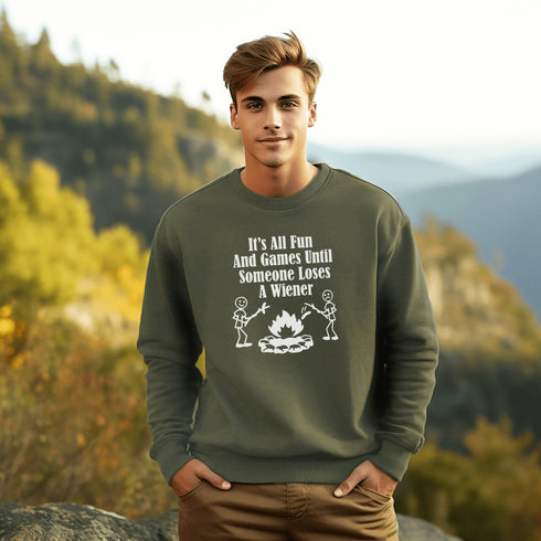 Our Camping sweatshirt features two stick people roasting wieners over a campfire with the hilarious saying, "It's All Fun & Games Until Someone Loses A Wiener."